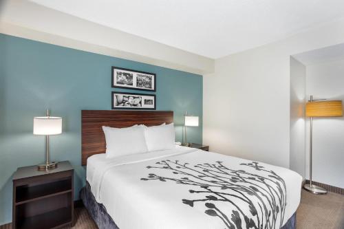 a hotel room with a large bed and two lamps at Sleep Inn near Penn State - State College, PA in State College