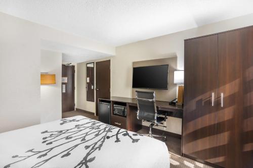 a hotel room with a bed and a desk and a television at Sleep Inn near Penn State - State College, PA in State College