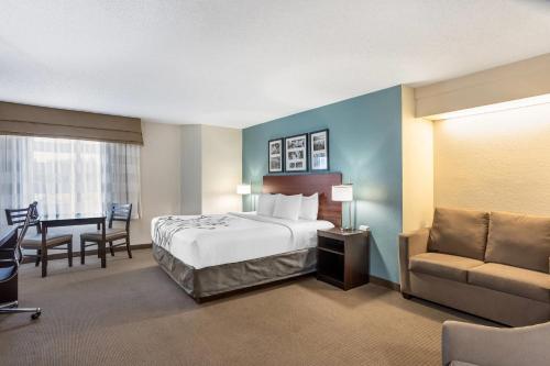 a hotel room with a bed and a chair and a desk at Sleep Inn near Penn State - State College, PA in State College