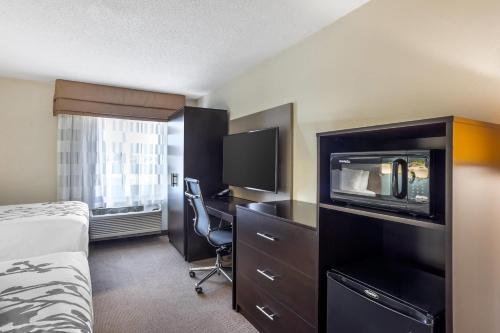 a hotel room with a bed and a desk with a tv at Sleep Inn near Penn State - State College, PA in State College