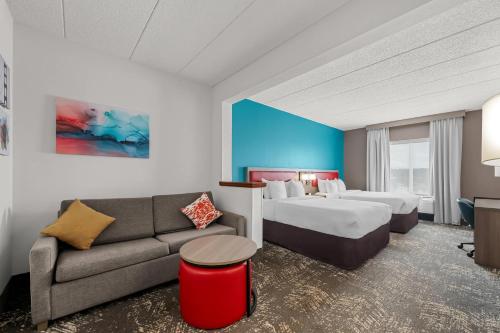 a hotel room with two beds and a couch at Comfort Suites Columbia at Harbison in Columbia