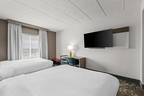 a hotel room with two beds and a flat screen tv at Comfort Suites Columbia at Harbison in Columbia