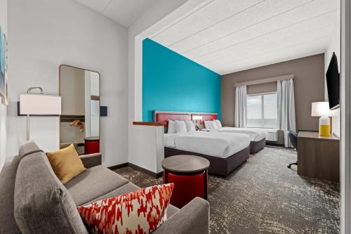 a hotel room with two beds and a couch at Comfort Suites Columbia at Harbison in Columbia