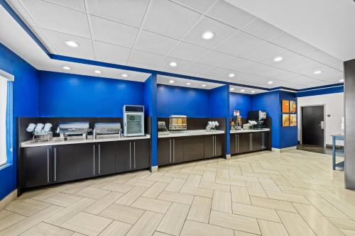 a large lobby with blue walls and counters at Comfort Suites Columbia at Harbison in Columbia