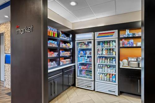 a grocery store aisle with refrigerators and drinks at Comfort Suites Columbia at Harbison in Columbia