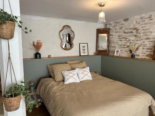 ein Schlafzimmer mit einem Bett mit Kissen und einem Spiegel in der Unterkunft A l'ombre des Charlemagnes in Pernand-Vergelesses
