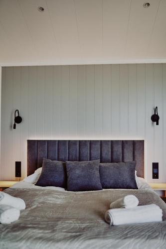 a bedroom with a large bed with two pillows at Domki Dollar -Plaża Nowe Guty in Nowe Guty