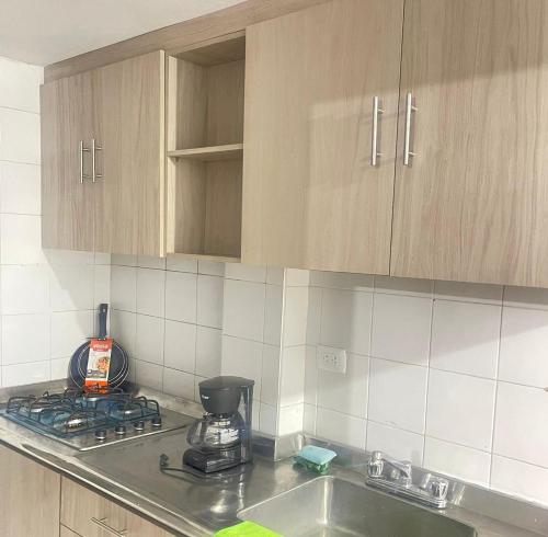 a kitchen with a sink and a stove and cabinets at Flowers House Aptos - Centro Histórico in Valledupar