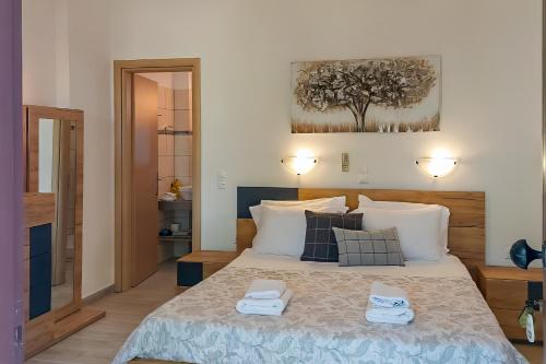 a bedroom with a bed with two towels on it at SKYROS AVRA Residences in Skiros