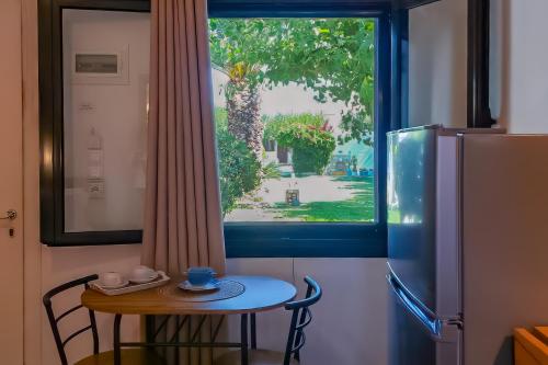 a small table and a window in a kitchen with a small table and a refrigerator at SKYROS AVRA Residences in Skiros