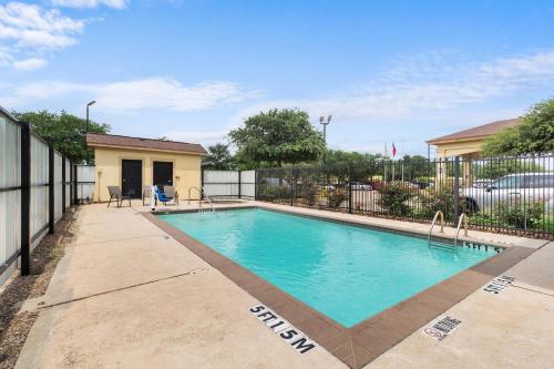 a swimming pool in front of a house at Sleep Inn & Suites Bush Intercontinental - IAH East in Humble
