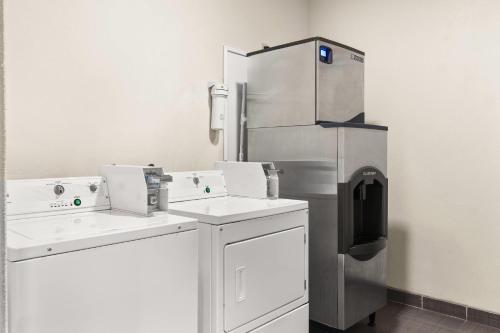 a kitchen with a stainless steel refrigerator in a room at Sleep Inn & Suites Bush Intercontinental - IAH East in Humble