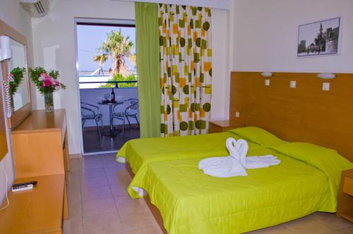 a hotel room with a bed with a swan on it at Hotel Tigaki's Star in Tigaki
