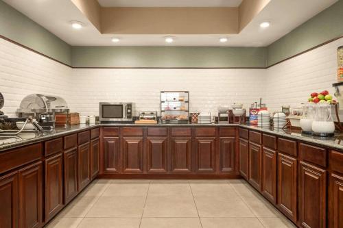 a large kitchen with wooden cabinets and appliances at Country Inn & Suites by Radisson, Lima in Lima
