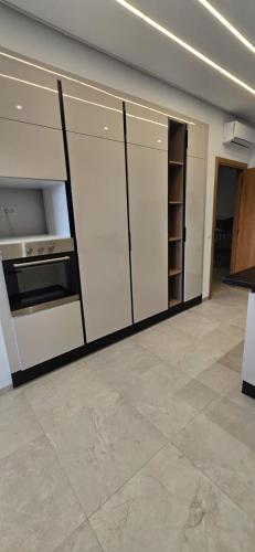 a kitchen with white cabinets and a stove at Le luxe MENZAH5 in Ariana