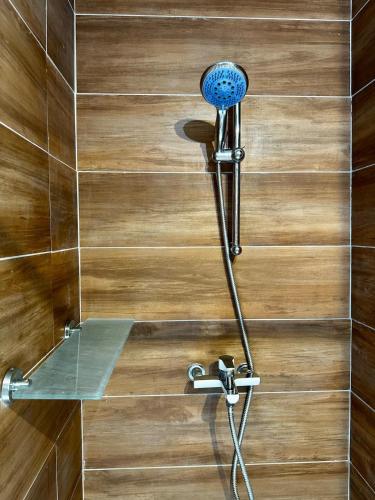 une douche avec un pommeau de douche bleu sur un mur dans l'établissement Maison fonctionnelle avec jardin et abordable, à Toulon