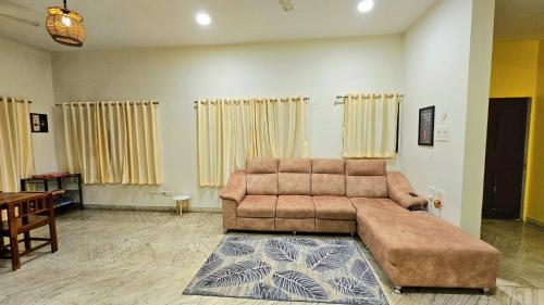 a living room with a brown couch and a table at Rostel Backpackers Hostel in Pune