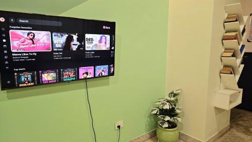 a flat screen tv hanging on a wall at Rostel Backpackers Hostel in Pune