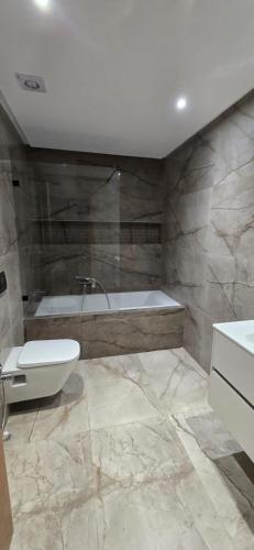 a bathroom with a tub and a toilet and a sink at Le luxe MENZAH5 in Ariana