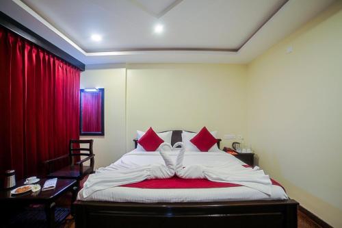 a bedroom with a bed with a red curtain at RivieraaHotel in Pondicherry