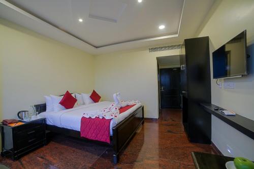 a bedroom with a bed and a flat screen tv at RivieraaHotel in Pondicherry