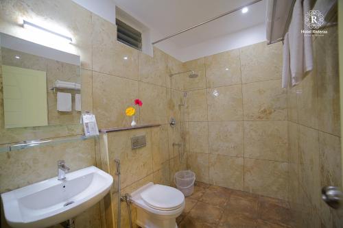 a bathroom with a sink and a toilet and a shower at RivieraaHotel in Pondicherry