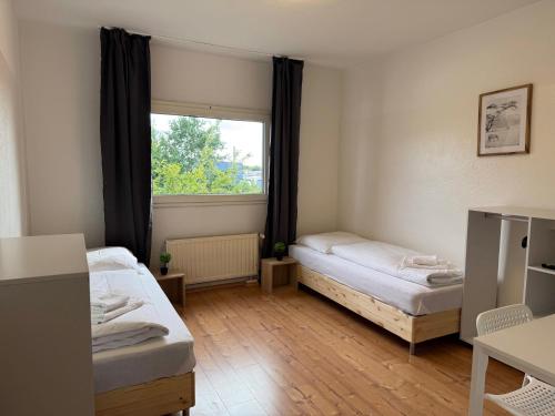 a room with two beds and a window at T&K Apartments - Nettetal - 3 Zimmer Wohnung - Privatparkplatz - 6 km bis Venlo in Nettetal