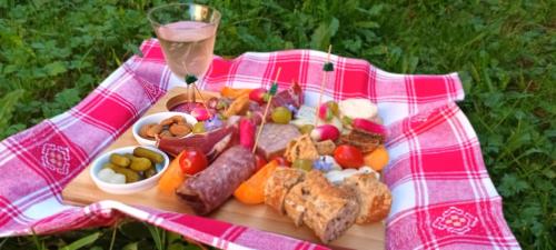 a plate of food on a picnic blanket with a glass of wine at La Provende in Bard