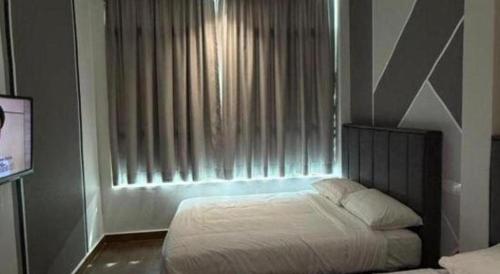 a bedroom with a bed in front of a window at Hotel Zamburger Bentong in Bentong