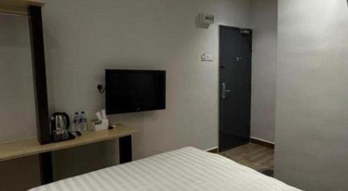 a bedroom with a bed and a tv on the wall at Hotel Zamburger Bentong in Bentong