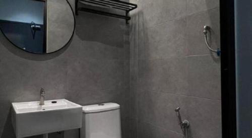 a bathroom with a sink and a toilet and a mirror at Hotel Zamburger Bentong in Bentong