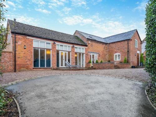 a brick house with a patio in front of it at Stable End in Whitchurch