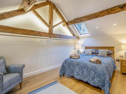 a bedroom with a bed and a chair at Stable End in Whitchurch
