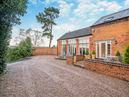 an exterior view of a brick house with a driveway at Stable End in Whitchurch