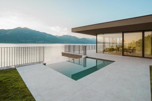 布雷佐内加尔达LUXE VISTA Lakeside Villa Brenzone的湖前带游泳池的房子