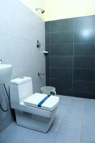a bathroom with a white toilet and a sink at Hotel ANNAI BAY in Velankanni