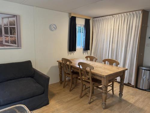 a living room with a table and chairs and a couch at KD 743 - Vakantiepark Kijkduin in The Hague