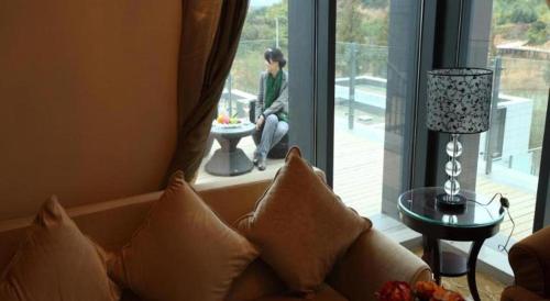a living room with a couch in front of a window at Suzhou Qingshan Conference Center in Suzhou
