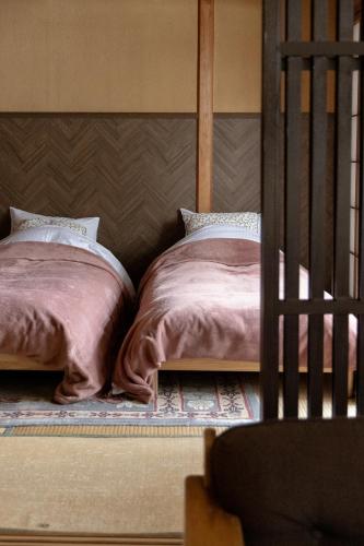 two beds sitting next to each other in a bedroom at Kogakuro in Myoko