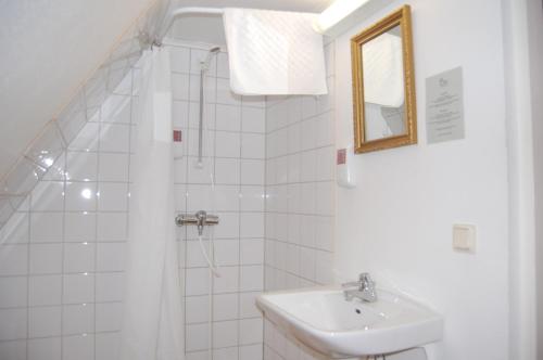 a white bathroom with a sink and a mirror at STF Vickleby Bo Pensionat in Färjestaden