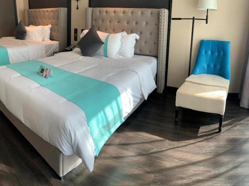 a hotel room with a large bed and a chair at Xana Hotelle Zhuhai Gongbei Port in Zhuhai