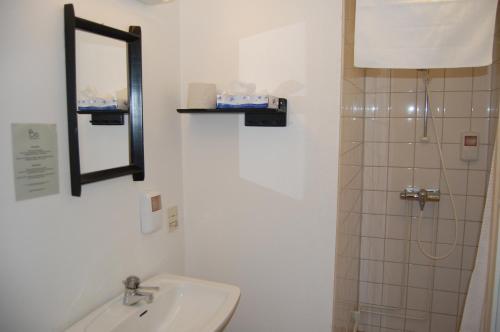 a bathroom with a toilet and a sink and a mirror at STF Vickleby Bo Pensionat in Färjestaden