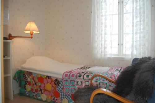 a bedroom with a bed and a lamp and a window at STF Vickleby Bo Pensionat in Färjestaden