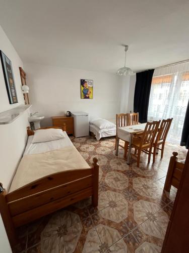 a bedroom with two beds and a table and chairs at Willa Rodzinna in Mielno
