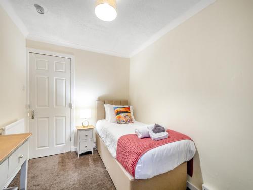 a small bedroom with a bed and a desk at Argyle House in Rothesay