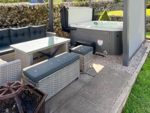 a patio with a table and a bath tub at Argyle House in Rothesay