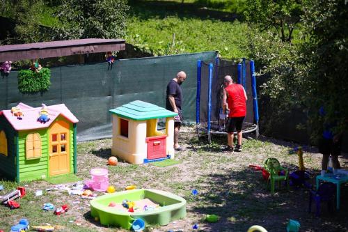 two men standing in a play yard with toys at Agropensiune Lupu 