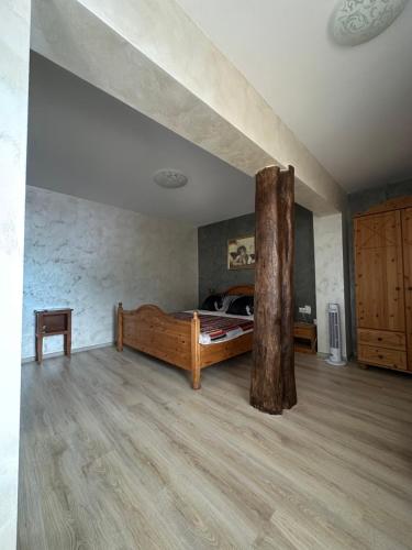 a room with a bed and a tree in it at Agropensiune Lupu 