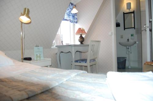 a bedroom with a bed and a desk and a sink at STF Vickleby Bo Pensionat in Färjestaden