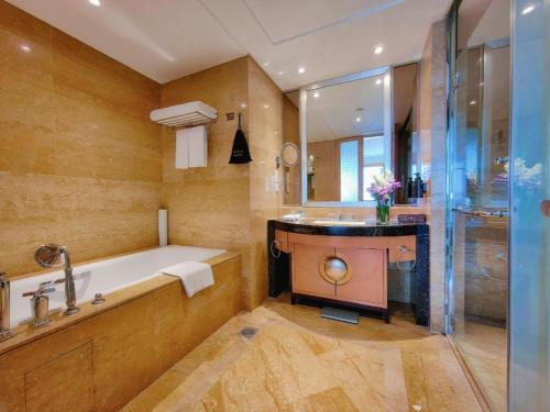 a bathroom with a tub and a sink and a shower at Radegast Hotel CBD in Beijing